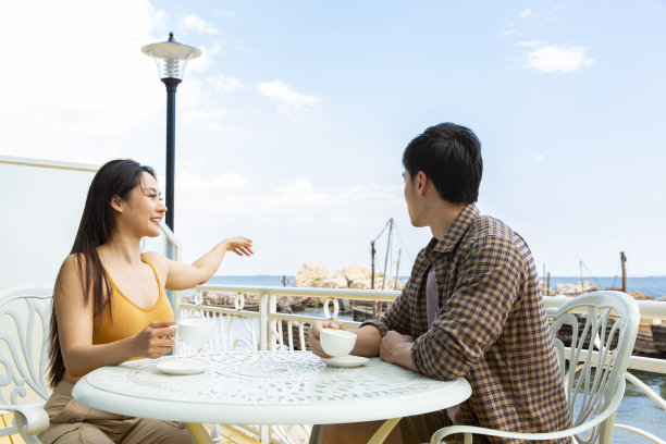 一对年轻夫妇在海景咖啡馆喝咖啡-照片图片下载