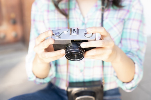 年轻女子拿着一台模拟摄像机。旅游度假概念图片下载
