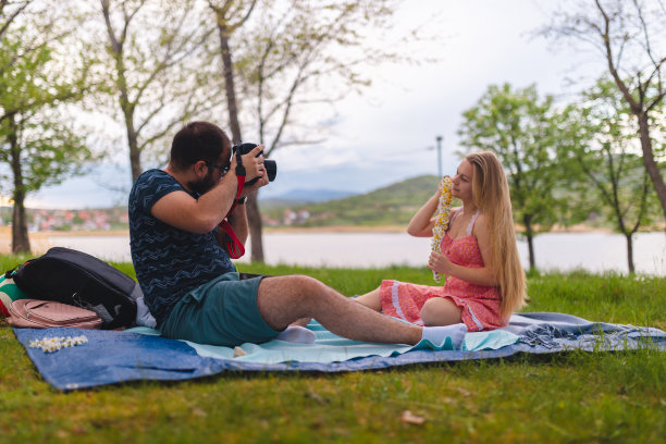 年轻浪漫的情侣在湖边放松的时候一起拍照图片下载