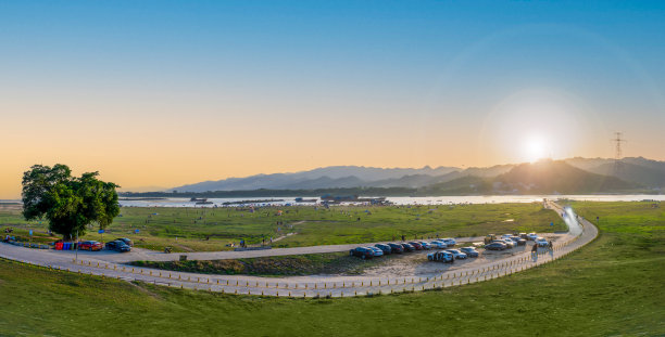 日落时分，河边草地上的榕树风光图片下载