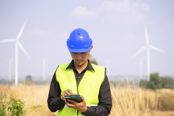 电力工地的蓝领工人。风车。图片下载