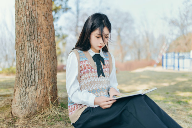 美丽的大学生们在公园里戴着耳机听音乐图片下载