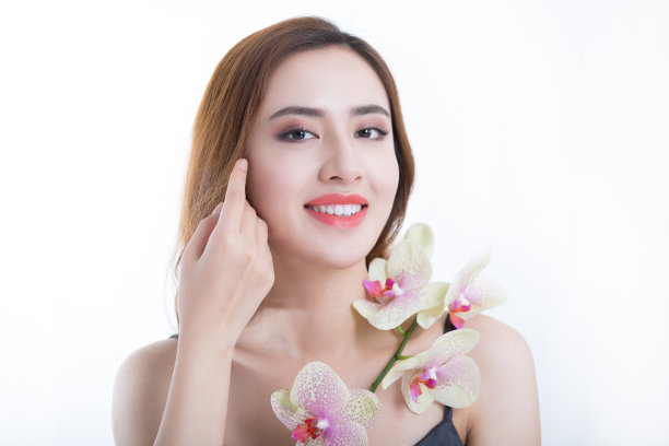 美丽的中国年轻女士微笑明亮的蝴蝶兰花，在白色背景-股票照片图片下载