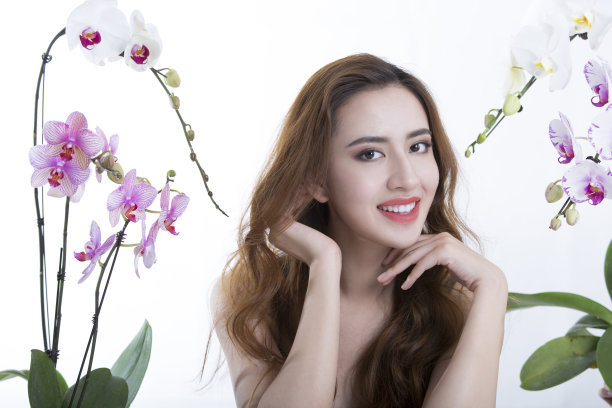 美丽的中国年轻女士微笑明亮的蝴蝶兰花，在白色背景-股票照片图片下载