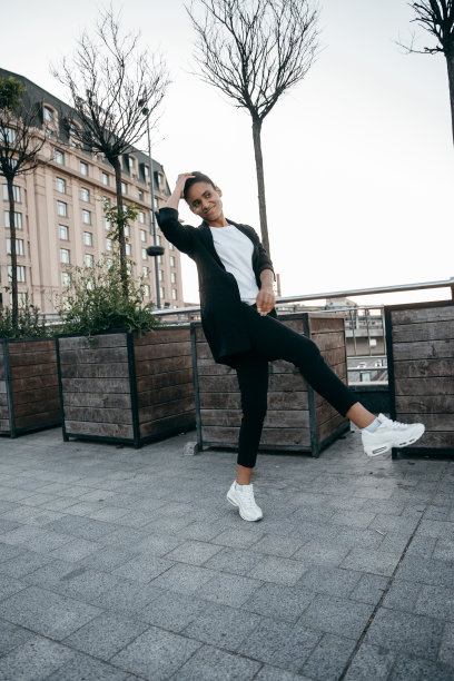 一位精力充沛、快乐的年轻美国黑人妇女抬起腿跳了起来图片下载