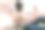 身穿棕色羊毛毛衣、头戴黑色帽子的女子坐在一座纪念碑上，一边看着她的手机。图片下载