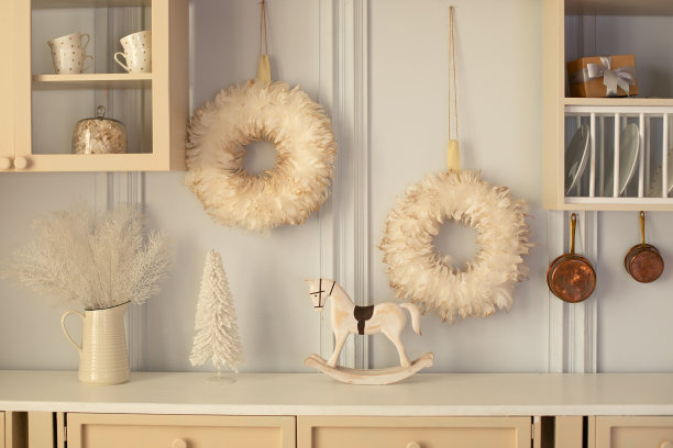 烹饪与舒适的家庭装饰。厨房内部有木制橱柜和装饰，器皿，锅和盘子。厨房桌面上的炊具和陶瓷盘子。圣诞节，小雕像摇马图片下载