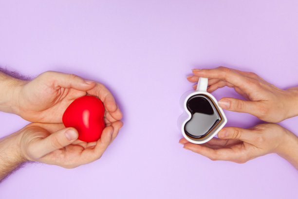 女人手捧心形咖啡杯，男人手捧红心图片下载