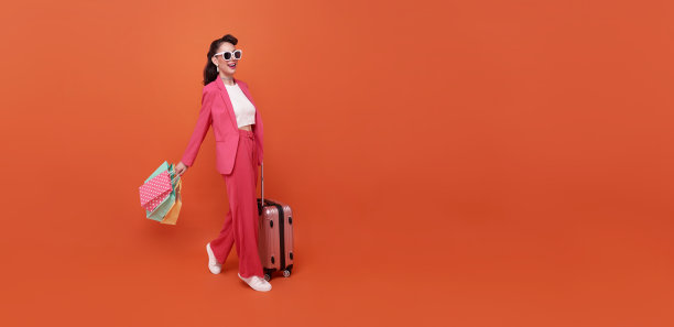 快乐快乐的女人享受购物，她带着购物袋，走在购物中心获得最新的优惠。图片下载