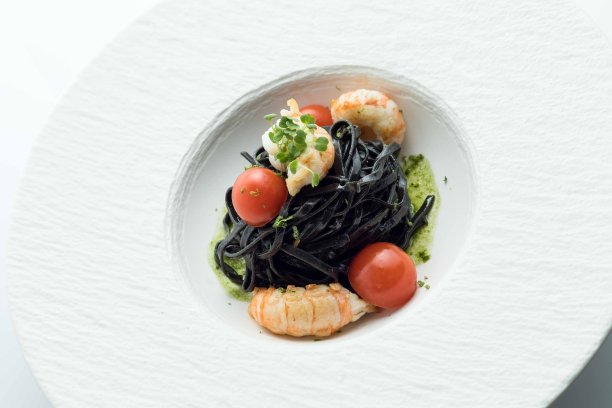 女人吃着黑意大利面和海鲜图片下载