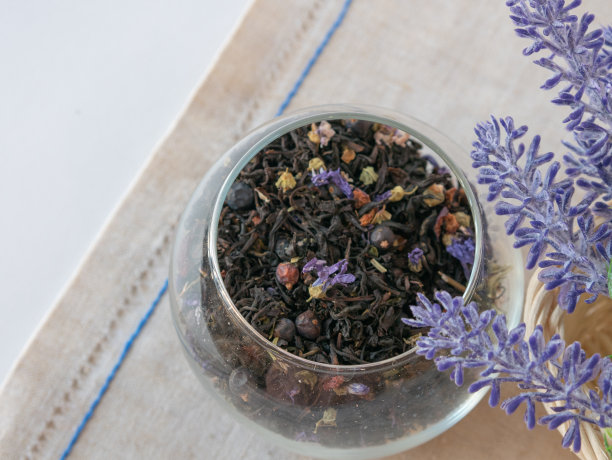 草药茶，蓝色干花，圆玻璃花瓶，帆布餐巾，薰衣草花图片下载