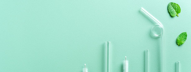 可重复使用的玻璃吸管和清洁刷设置在绿色的桌子背景。图片下载