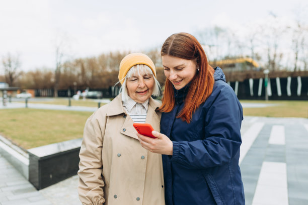 女性使用智能手机来寻找她们在户外感兴趣的东西。在互联网上搜索信息数据，联网概念。朋友们在智能手机上看视频图片下载
