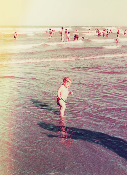 一个婴儿第一次把脚浸在海水里图片下载