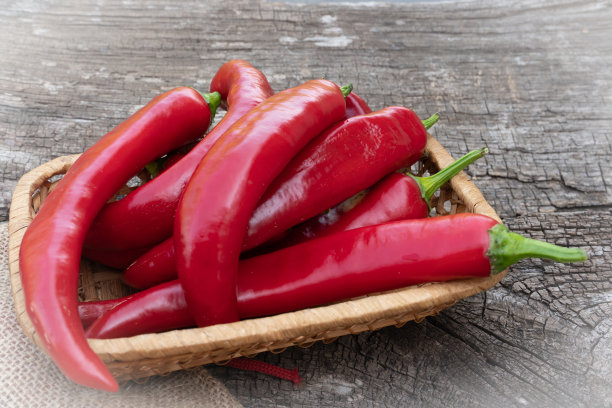 木制背景上放了很多红辣椒。红辣椒特写镜头。图片下载