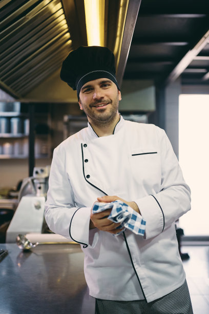 在餐馆工作的专业男厨师看着镜头。图片下载