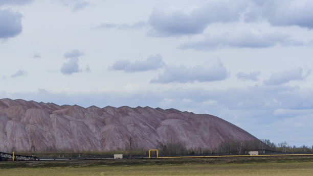 在多云的天空背景下开采钾矿时的空矿山。把一块空石头运到垃圾场。图片下载