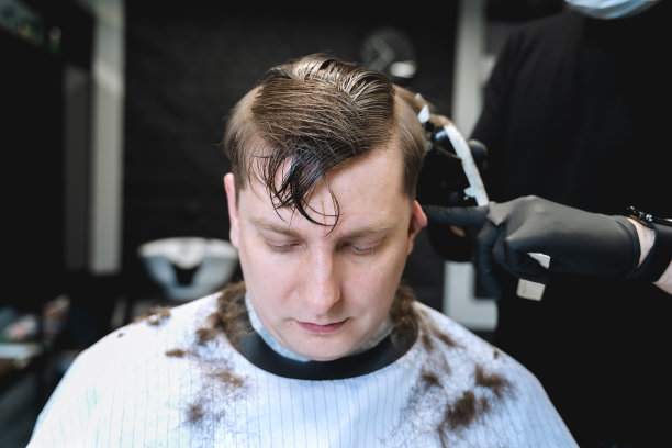 去理发店。男人做时尚的发型、发型。剃去寺庙,。理发师理发推子图片下载