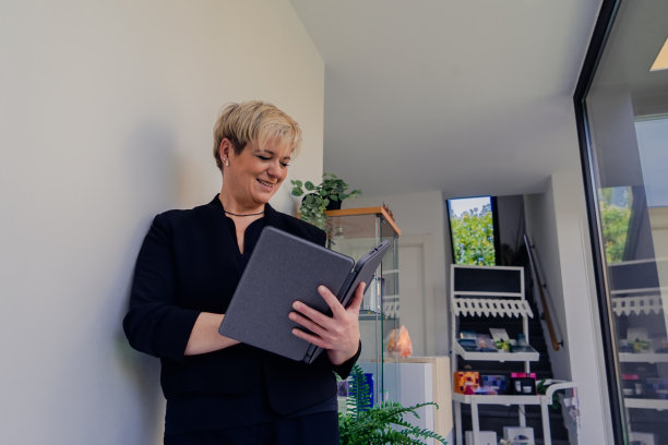 成熟的金发女人看着她的平板电脑。工作中的女商人。低角度查看器图片下载