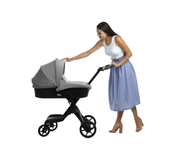 快乐的年轻女子与婴儿推车在白色背景图片下载