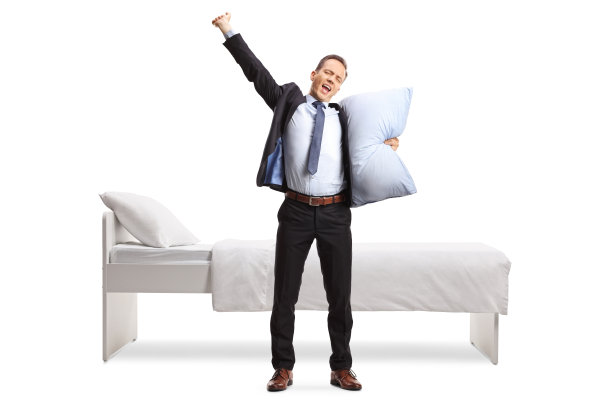 一个商人拿着枕头在床前打呵欠的全身像图片下载