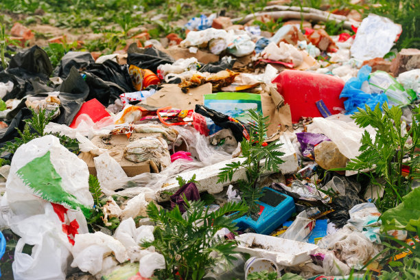 散焦巨大的垃圾填埋场。生态学的概念。大型垃圾堆在大自然绿草的背景下，全球变暖。特写镜头。污染。的焦点图片下载