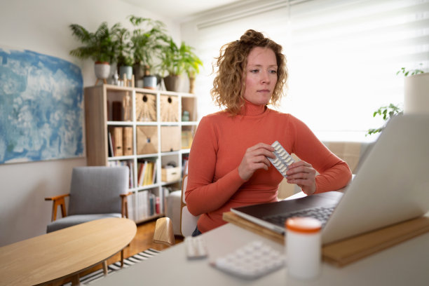 女病人在视频通话中向她的医生展示她服用的药物图片下载