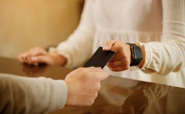 前台女孩手里拿着探照卡。关闭了。前台的女主人拿着公司或酒店的名片。放置logo的地方图片下载