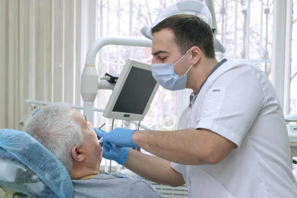 一位老人在牙科诊所接受治疗。医疗保健和医疗理念图片下载