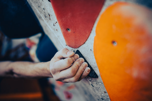 涂了镁粉的男性手抓着攀岩墙图片下载