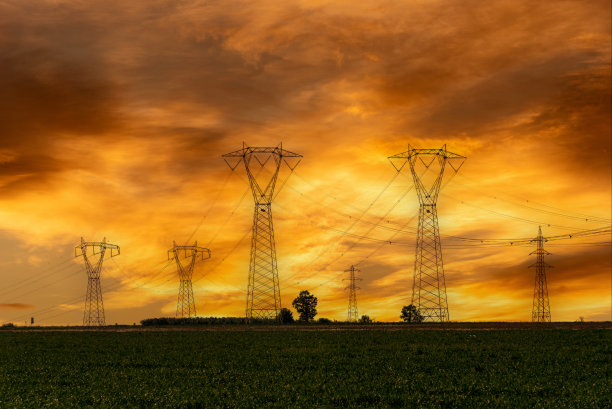 日落时分，高压电线在彩色多云的天空上图片下载