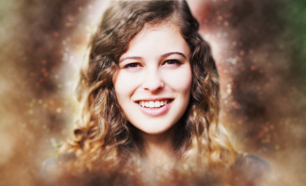 一个美丽的年轻女人对着镜头微笑的飘渺的肖像图片下载