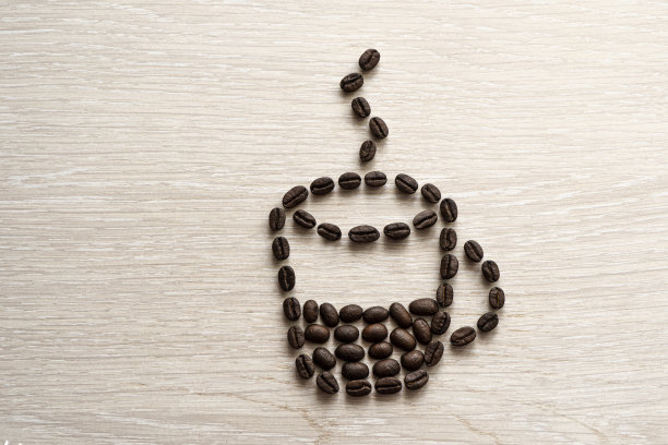 一张木桌上的咖啡豆特写镜头。白色桌子上的咖啡豆制成的咖啡杯。休息时间,图片下载