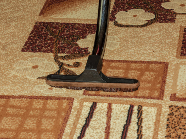 以地毯为背景的现代吸尘器的头部。关闭。图片下载