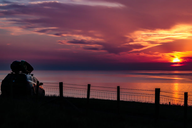 海上迷人的日落，彩色的天空和云，可以乘坐带冲浪板的汽车俯瞰图片下载