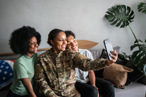 士兵母亲与女儿和儿子在家里用手机视频通话(或自拍)图片下载