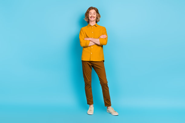 全长身体有吸引力的开朗高兴的内容的观点折叠双臂孤立在明亮的蓝色背景图片下载