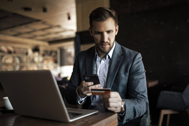 年轻的商人在网上购物时持有信用卡图片下载