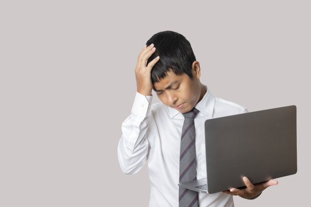 肖像商人使用笔记本电脑感到失望，不高兴和消极的姿态。图片下载