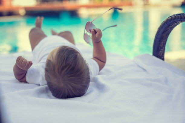 宝宝在豪华游泳池附近放松图片下载