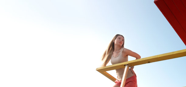 迈阿密南海滩彩色救生员小屋里的漂亮金发女郎图片下载