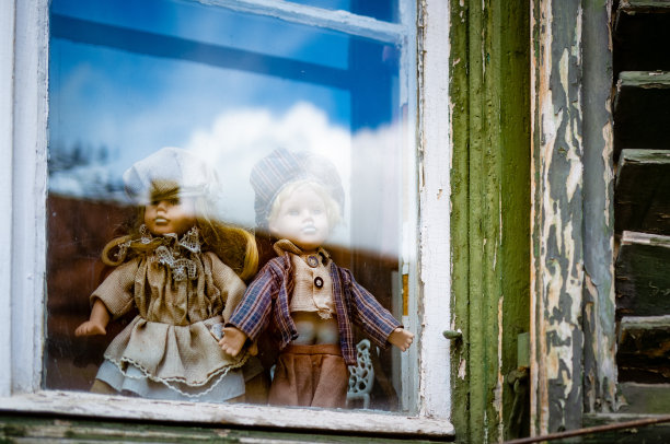 在玻璃窗后面牵着手的娃娃素材图片