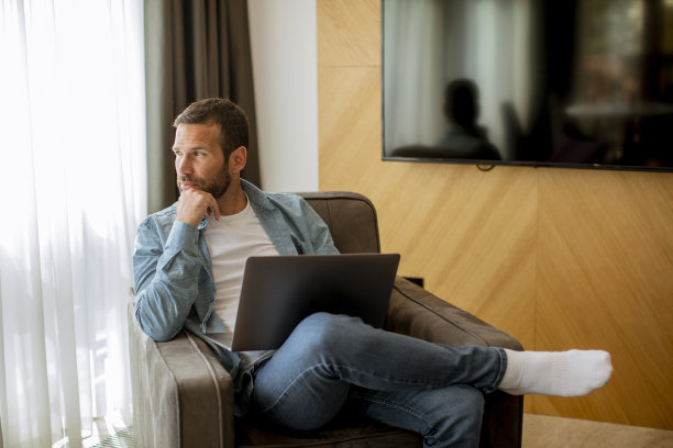 年轻人在客厅用笔记本电脑图片下载