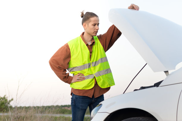 一个深思熟虑的年轻人看着他的汽车引擎，这样他就能在天黑前把它修好并赶回家图片下载