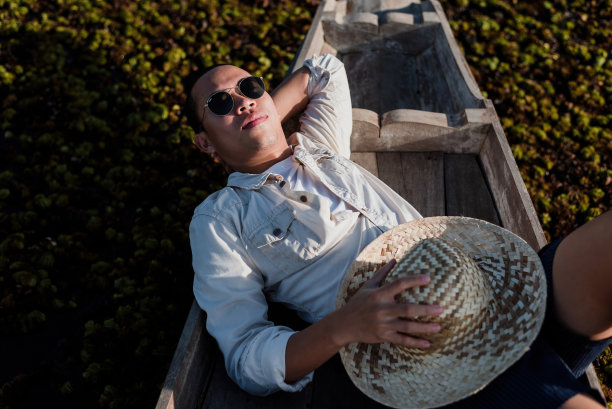 在一条长尾船上，一个亚洲人正在睡觉。图片下载