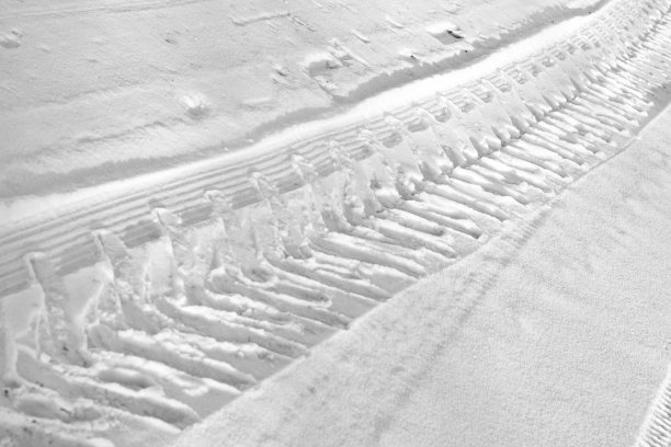 白色和黑色汽车轮胎在雪地上的痕迹特写。图片下载