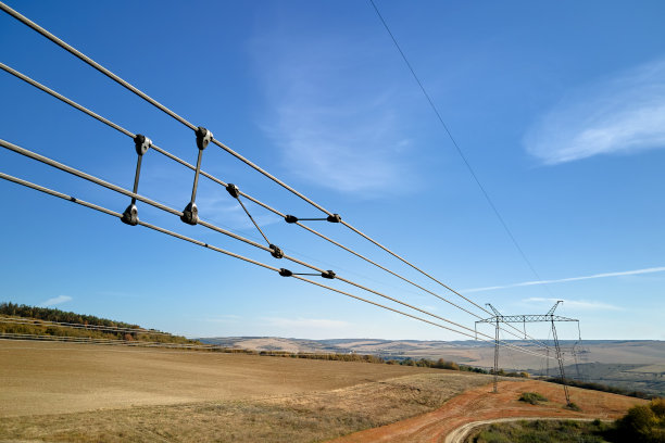 高压塔的电力线路由安全保护套管分隔，通过电缆将电能安全转移。长距离输电的概念图片下载