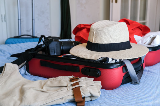 女人把衣服叠在旅行箱里，夏天旅行时用的行李图片下载