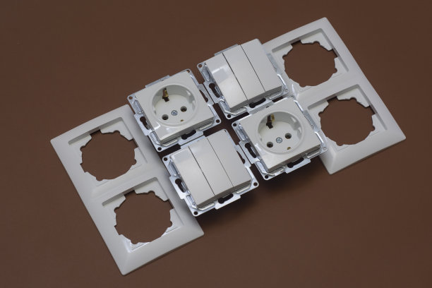 棕色背景上的家用塑料插座和电源开关。图片下载