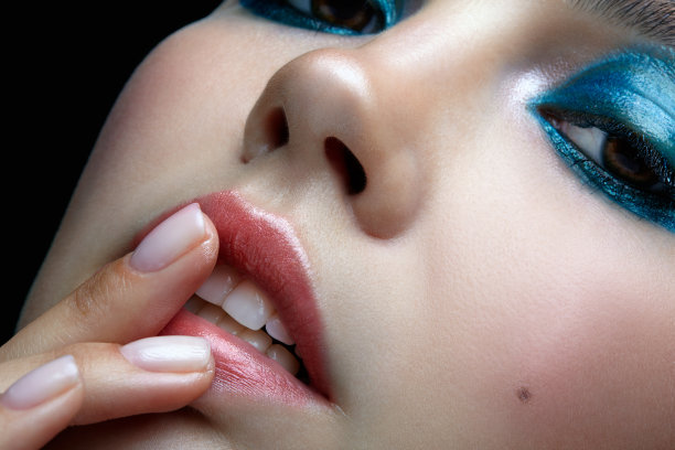 特写微距肖像的女性脸与手指的嘴唇。女人用晚妆图片下载